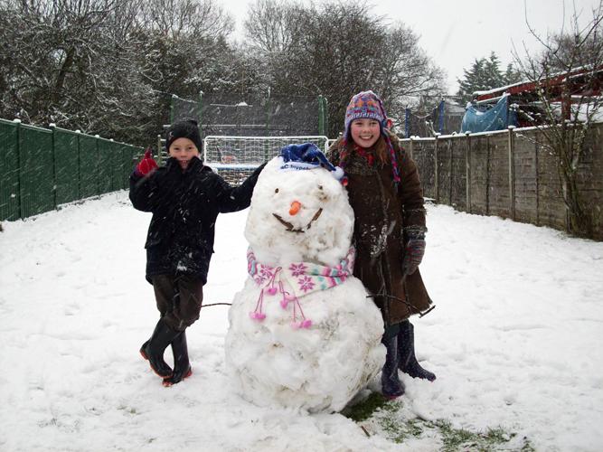 Sophie and Joseph Chambers with their snowman.



