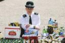SHOCKING: Police officer Kerry Loveless, pictured at Shirley police station with bottles and cans of booze taken off kids drinking in the streets.