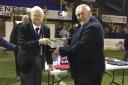 Peter Raynbird (left) being presented with a crystal bowl on the pitch by Mick Davis