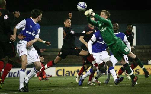 Oldham keeper Ben Amos punches the ball away under pressure. A selection of images from Saints' 6-0 romp against Oldham at Boundary Park.
