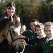 Fiona King introduces New Forest pony Knightwood Minx to children from Bassett Green Primary School, Southampton, l to r, Kacper Lewandowski, David McKenzie and Gosia Marczak, all 8