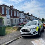 Police cordoned off the house after three people were stabbed on Friday