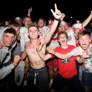 Fans at the Isle of Wight Festival celebrate England's goal.