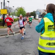 A milemaker cheering on runners at last year's event