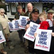Mike and Debbie Mills and their daughter Dorothy are joined by customers and villagers to back the Daily Echo Buy Local, Shop Local campaign.