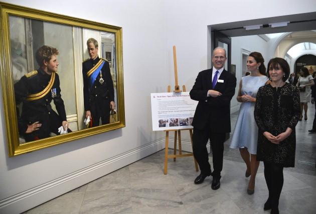The Duchess of Cambridge views a painting of her husband the Duke of Cambridge and brother-in-law Prince Harry, accompanied by National Portrait Gallery director Sandy Nairne and Art Room charity founder Juli Beattie (right) during a visit to the National