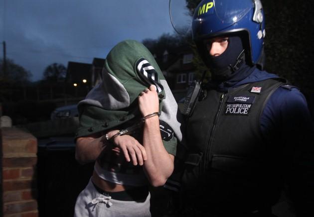 Police make an arrest during an early morning raid in response to recent football violence amongst Millwall fans.
Picture date: Tuesday April 23, 2013.