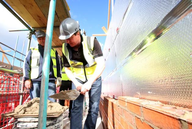 Prime Minister David Cameron, lays bricks during a visit to a small building site in Buckshaw Village in Chorley, Lancashire.
Picture date: Friday April 26, 2013.