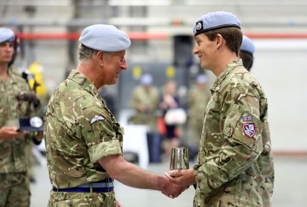 The Prince of Wales, Colonel-in-Chief Army Air Corps presents Major Simon Beattie, with a trophy as the Air Corps' Best Aircraft Commander of the Year of 662 squadron Army Air Corps at Wattisham flying station in Suffolk, as he presented operational servi