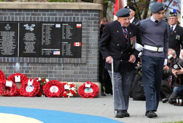 Dinger Bell (100) a Flight Seargant at RAF Grangemouth and flight mechanic is assisted by Cadet Dean McCarney as he lays a wreath during a ceremony to unveil a replica Spitfire as a memorial to 71 trainee pilots who lost their lives during the Second Worl