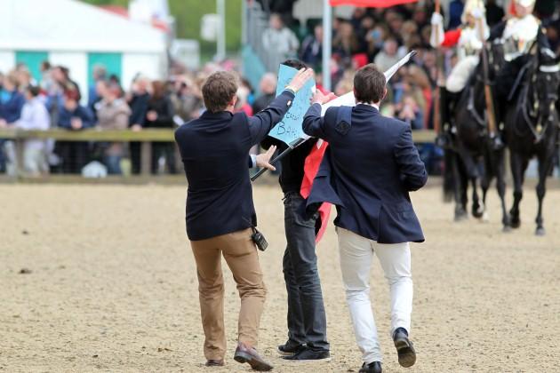 A man protesting against the King of Bahrain is led away after running onto the Main Arena during day four of the Royal Windsor Horse Show at Windsor Castle, Berkshire.
Picture date: Saturday May 11, 2013. 