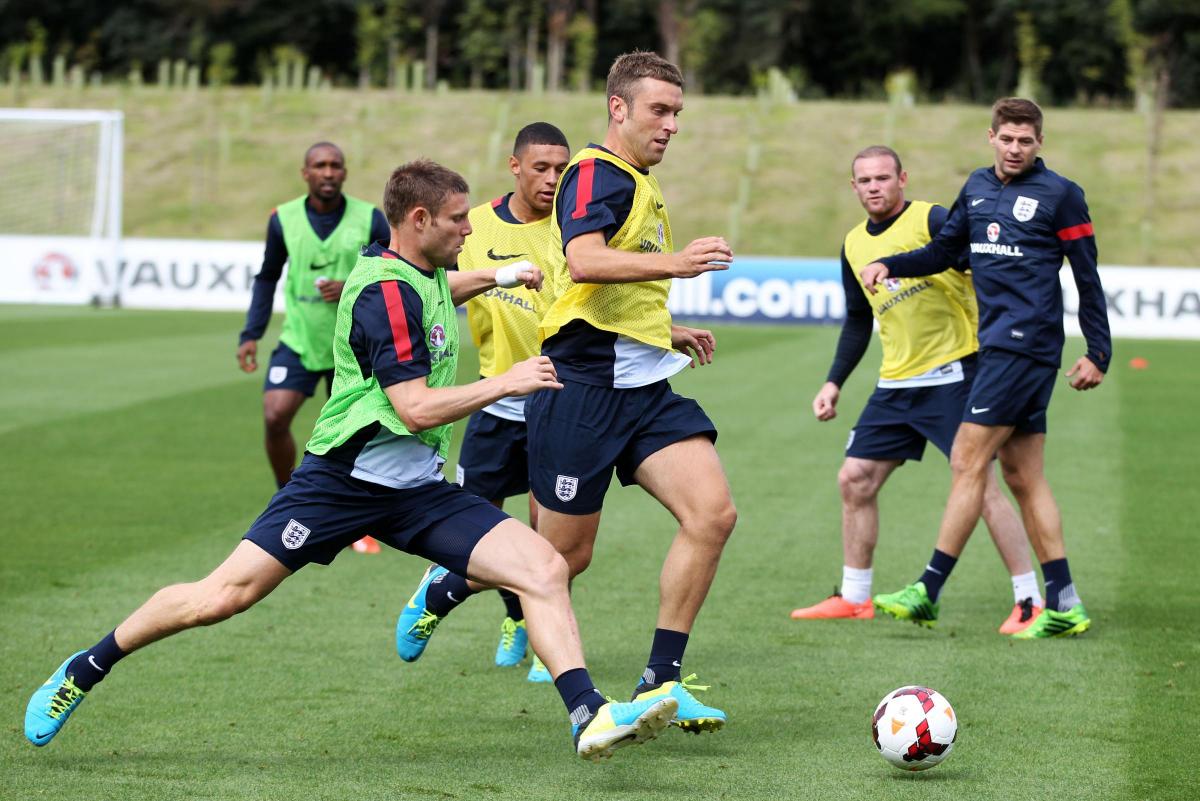 Rickie Lambert holds off James Milner while training with the England squad
