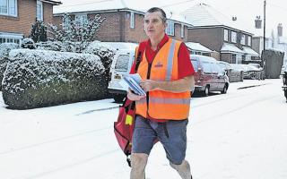 Postman Dave Martin, age 60, battles through the snow in shorts and T-shirt to deliver his letters in Hamble.