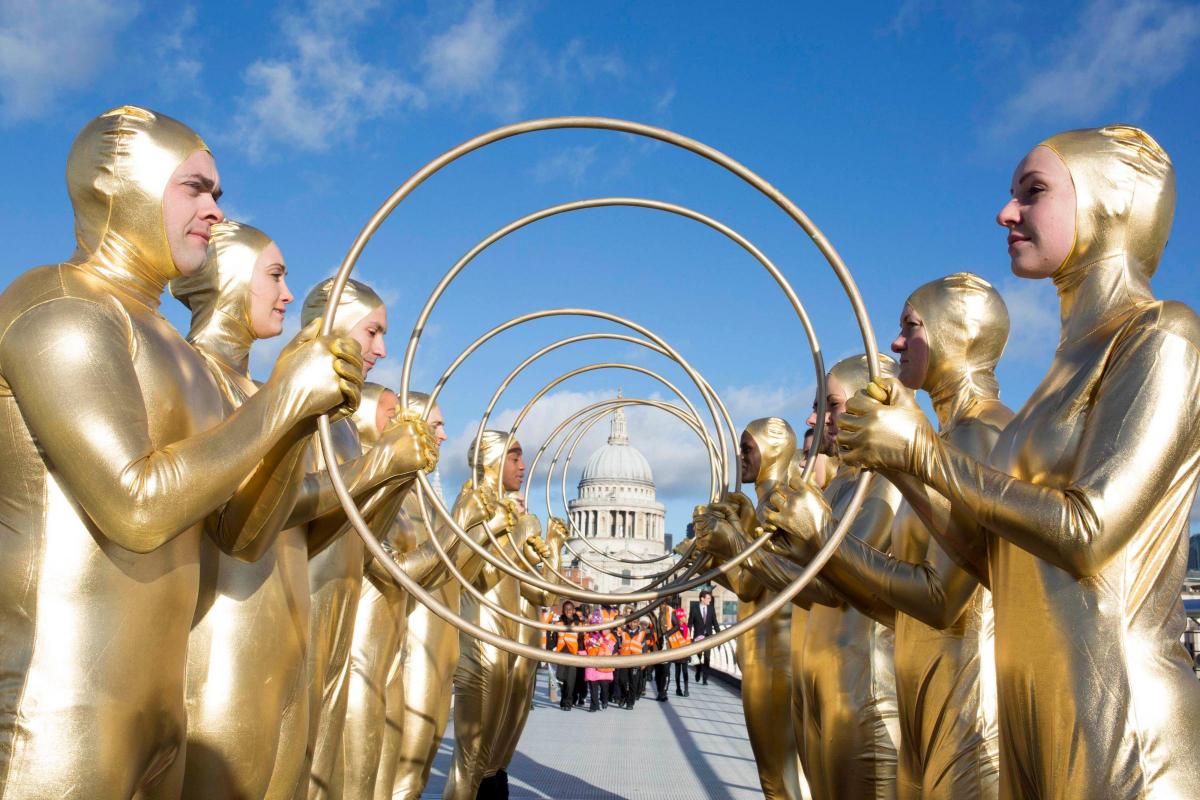 A
human
ring
of
gold
is
formed
on
the
Millennium
Bridge
in
front
of
St
Paul’s
Cathedral
in
central
London
to
highlight
the
launch
of
Fairtrade
Foundation’s
new
bridal
campaign,
I
Do. Picture of the Day for January 15, 2015.