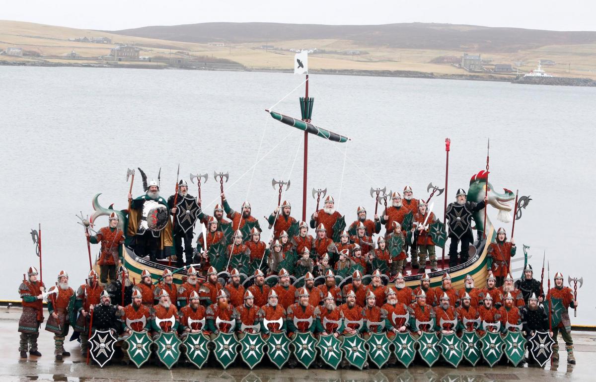 Members
of
the
Jarl
Squad
dressed
in
Viking
costumes
with
a
Viking
galley
in
Lerwick
on
the
Shetland
Isles. Picture of the day for January 28, 2015.