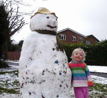 Snow covers Hampshire - Molly Lewis (2) with her special Snowman at Hedge End