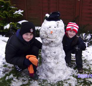 Snow covers Hampshire - Harrison and Thomas Cox with their snowman