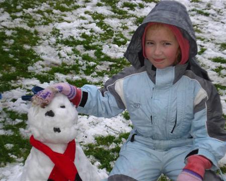 Snow covers Hampshire - Eight year old Millie Barefoot with her snowman