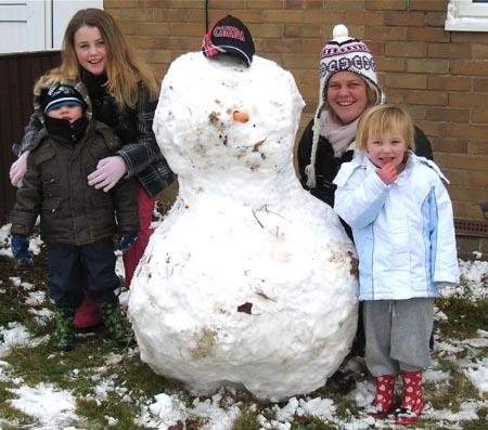 Snow covers Hampshire - The Baker family with their snowman