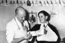 Nurse Charlie Windebank drawing a budgie on a patient's plaster cast.