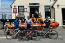 Cyclist Harry Lidgley, centre, with two friends, George Hayes and Oli Dawe-Lane, and members of the Calshot RNLI crew. Picture: Calshot RNLI.