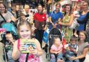 Charlotte Hodge, 4, (front) with storyteller Becky Timms (in red) and parents and children at the Disney Store, Marlands, at an event designed to get more parents reading to their children