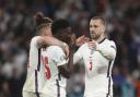 England's Kalvin Phillips, left, and Luke Shaw, right, comfort teammate Bukayo Saka after he failed to score a penalty during a penalty shootout after extra time during of the Euro 2020 soccer championship final match between England and Italy at