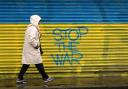 A woman walks past anti-war graffiti in support of Ukraine, painted on shutters in Dublin city centre, following Russia's invasion of Ukraine. Picture date: Wednesday March 2, 2022. (Credit: PA)