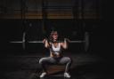 A woman weightlifting. Credit: Canva