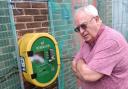 Robert Harland next to the defibrillator that  is no longer blocked by fencing