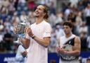 Alexander Zverev, of Germany, left, poses with the trophy after he won the men’s singles final of the U.S. Open tennis championships against Ben Shelton, of the United States, Sunday, Sept. 13, 2026, in New York. (AP Photo/Adam Hunger)