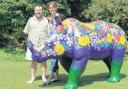 Mouth and foot artist Tom Yendell with wife Lucy and the rhino he has decorated for the project.