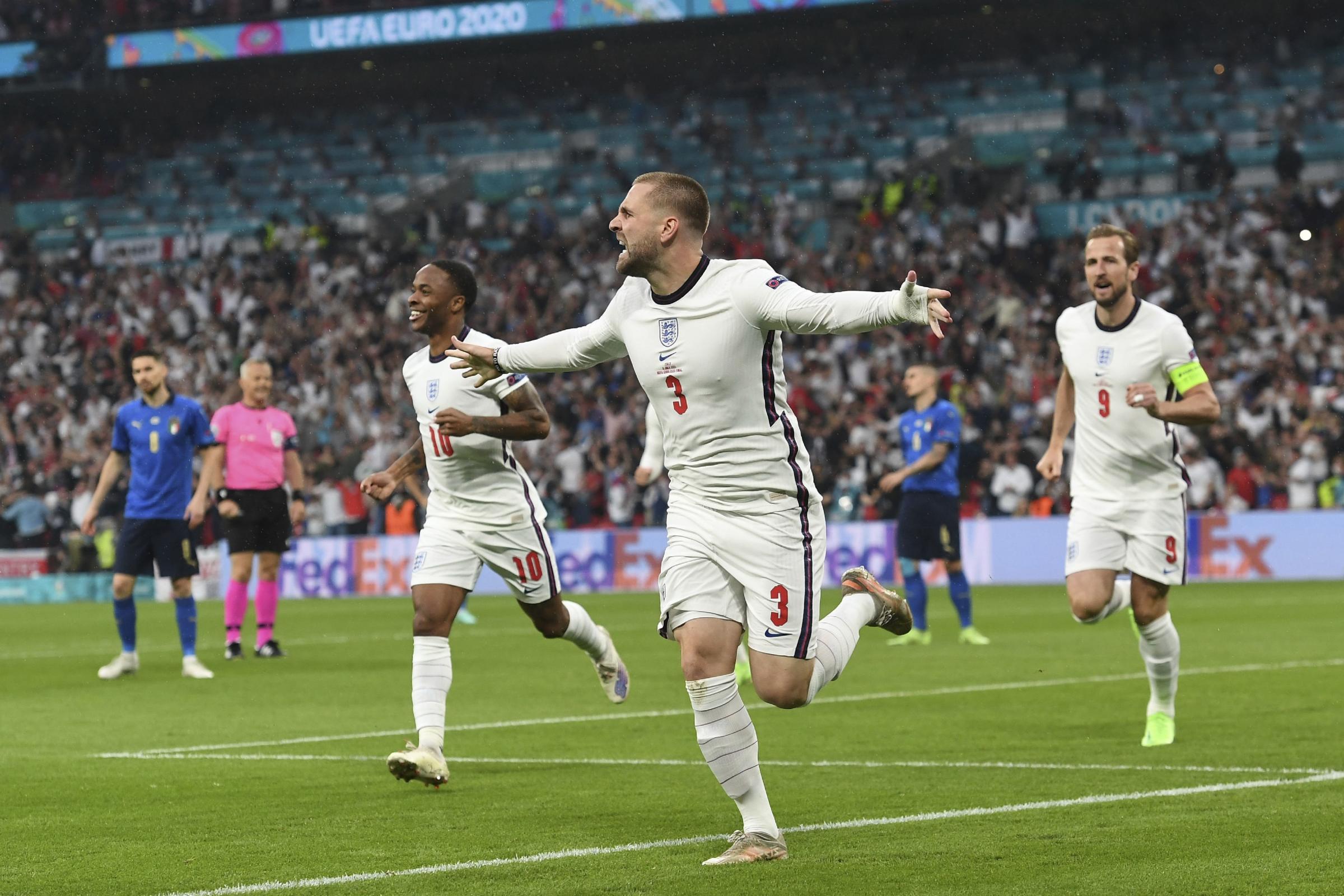 Englands Luke Shaw, center, celebrates after scoring his sides opening goal during the Euro 2020 soccer final match between England and Italy at Wembley stadium in London, Sunday, July 11, 2021. (Andy Rain/Pool Photo via AP).