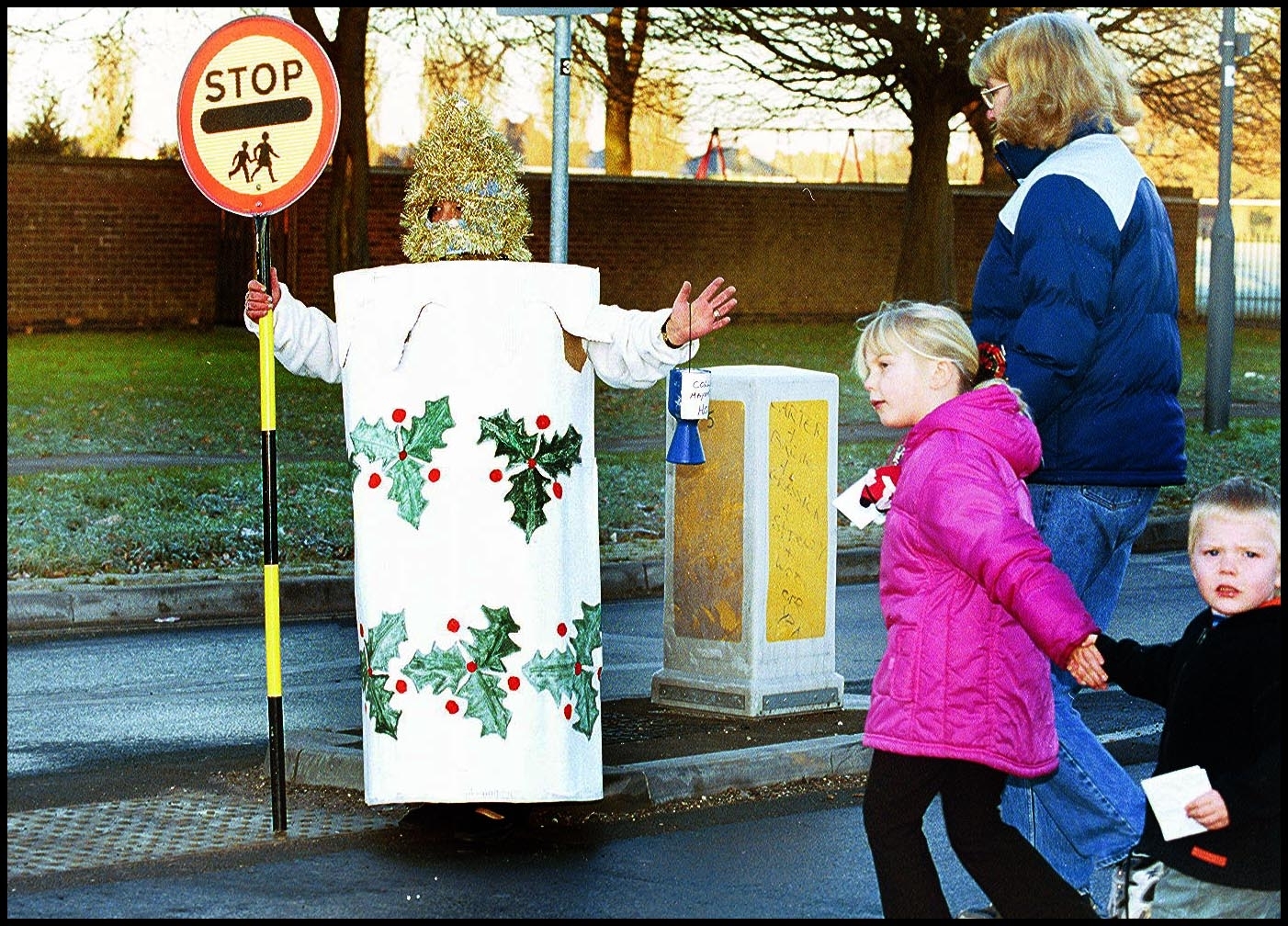 Lollipop lady Margaret Russell dressed as a Christmas Candle sees her charges safley to school..