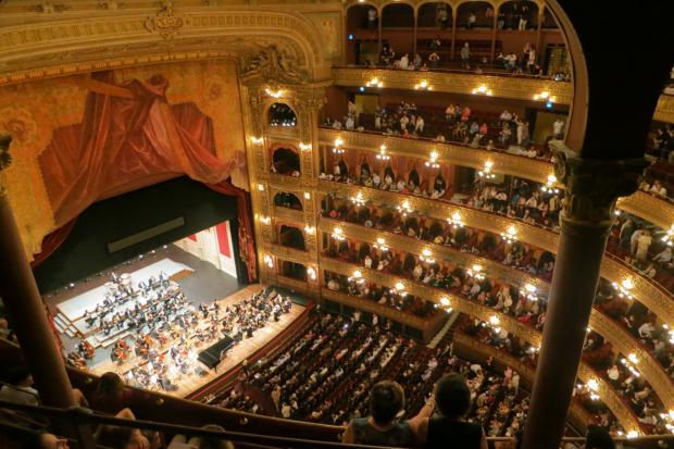 Daily Echo: A grand theatre with people watching an orchestra. Credit: Canva