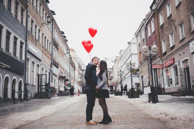 Daily Echo: A couple embracing on the street in front of heart balloons. Credit: Canva