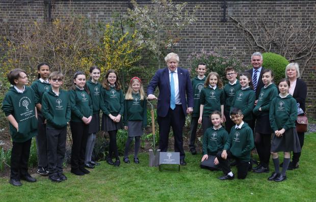 Daily Echo: Prime Minister Boris Johnson plants a tree in the garden of No10 Downing Street with school children from Sholing Junior School in Southampton. Picture by Andrew Parsons / No 10 Downing Street