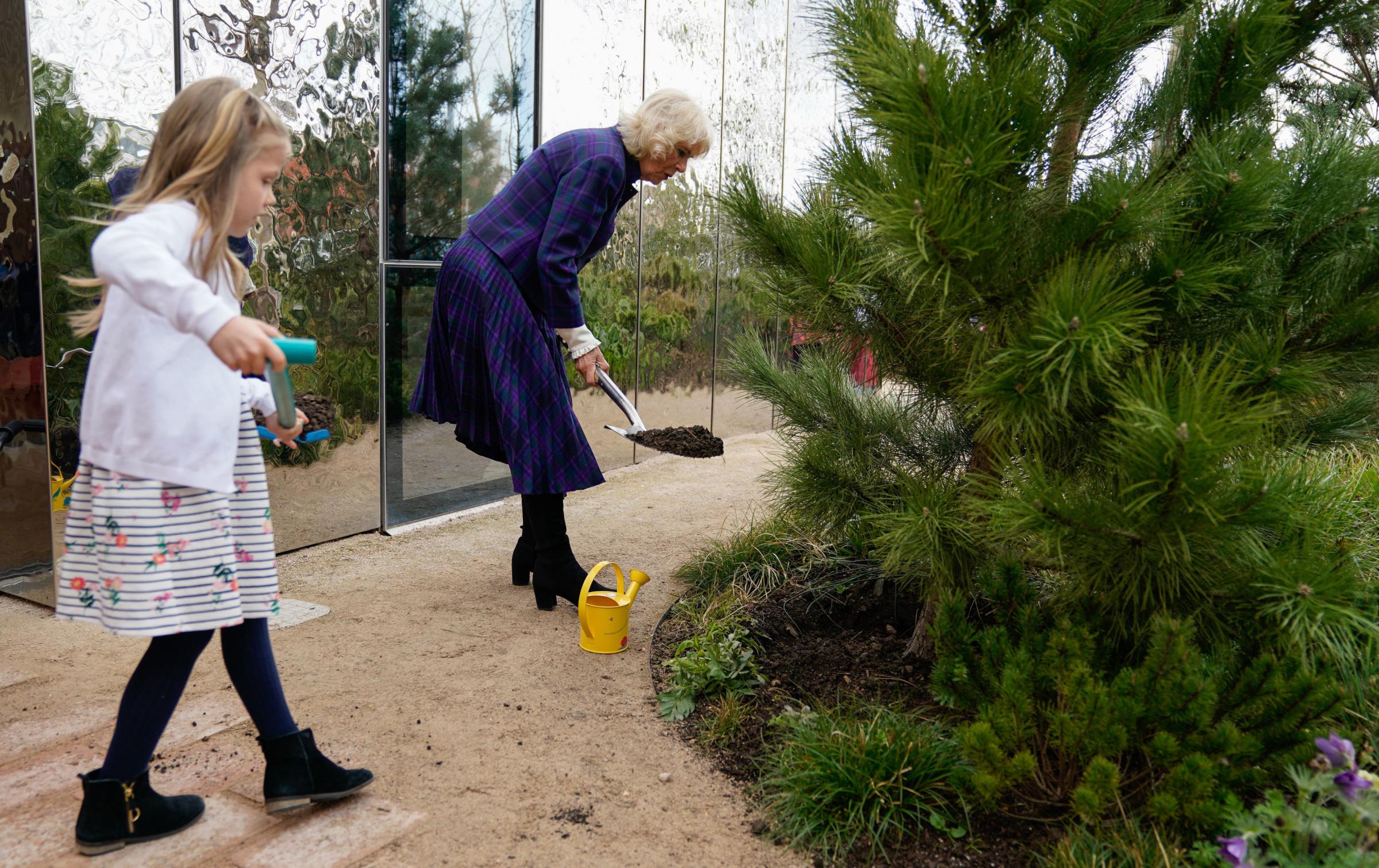 The Duchess of Cornwall (right) helps plant a tree with Isabelle Hewson during a visit to the charity Maggies Southampton in the grounds of University Hospital Southampton. Picture date: Wednesday April 6, 2022. PA Photo. See PA story ROYAL Camilla.