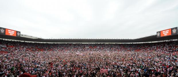 Daily Echo: Saints fans invade the pitch after confirming promotion to the Premier League. Image by: PA