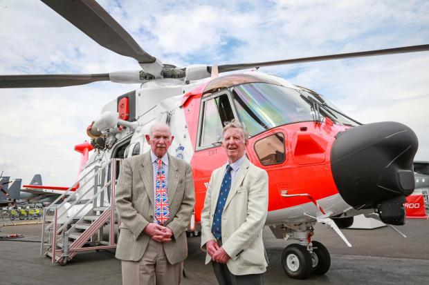 From left: Barnbrook Systems managing director Tony Barnett and Sir Donald Spiers, then chairman of Farnborough Aerospace Consortium, at the 2018 Farnborough International Airshow in front of a helicopter with Barnbrook System's fuel switch