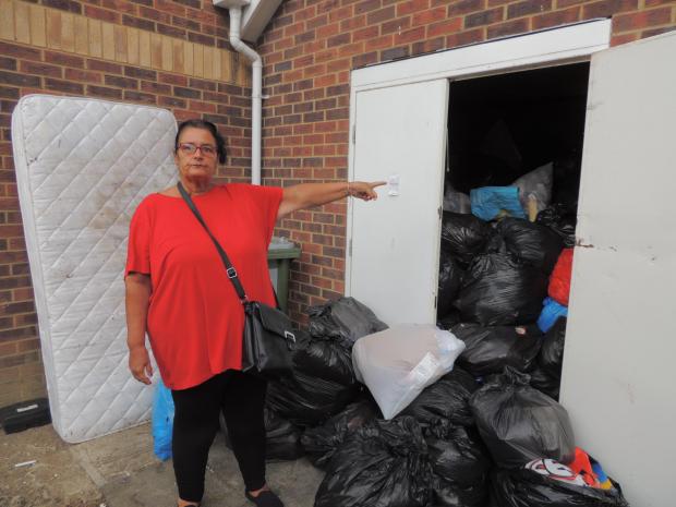 Daily Echo: Valerie John outside the overflowing bin store at the block of flats on Shirley Road, Southampton