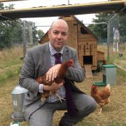 Head teacher Jason Ashley with one of the chickens in Lucy's Garden.