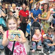 Charlotte Hodge, 4, (front) with storyteller Becky Timms (in red) and parents and children at the Disney Store, Marlands, at an event designed to get more parents reading to their children