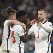 England's Kalvin Phillips, left, and Luke Shaw, right, comfort teammate Bukayo Saka after he failed to score a penalty during a penalty shootout after extra time during of the Euro 2020 soccer championship final match between England and Italy at
