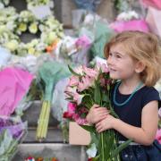 Floral tributes placed on the steps of the Civic Centre in memory of The Queen. 4 year old Annabella Zarina lays flowers.