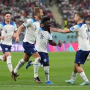 England's Bukayo Saka (centre) celebrates scoring their side's fourth goal of the game during the FIFA World Cup Group B match at the Khalifa International Stadium in Doha, Qatar. Picture date: Monday November 21, 2022.