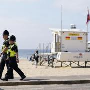 Police officers walk along Bournemouth beach front after a 17-year-old-boy and a girl aged 12 sustained 