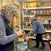 Volunteer Teri Palmer, 62, helps shopper Adam Drapcsik