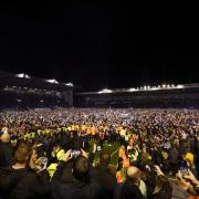 Portsmouth fans celebrate on the pitch after securing the League One title at Fratton Park on Tuesday night