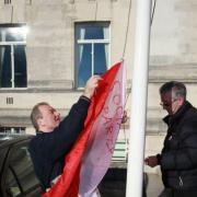 Mike King raises the Socialist Party flag at the Civic Centre.